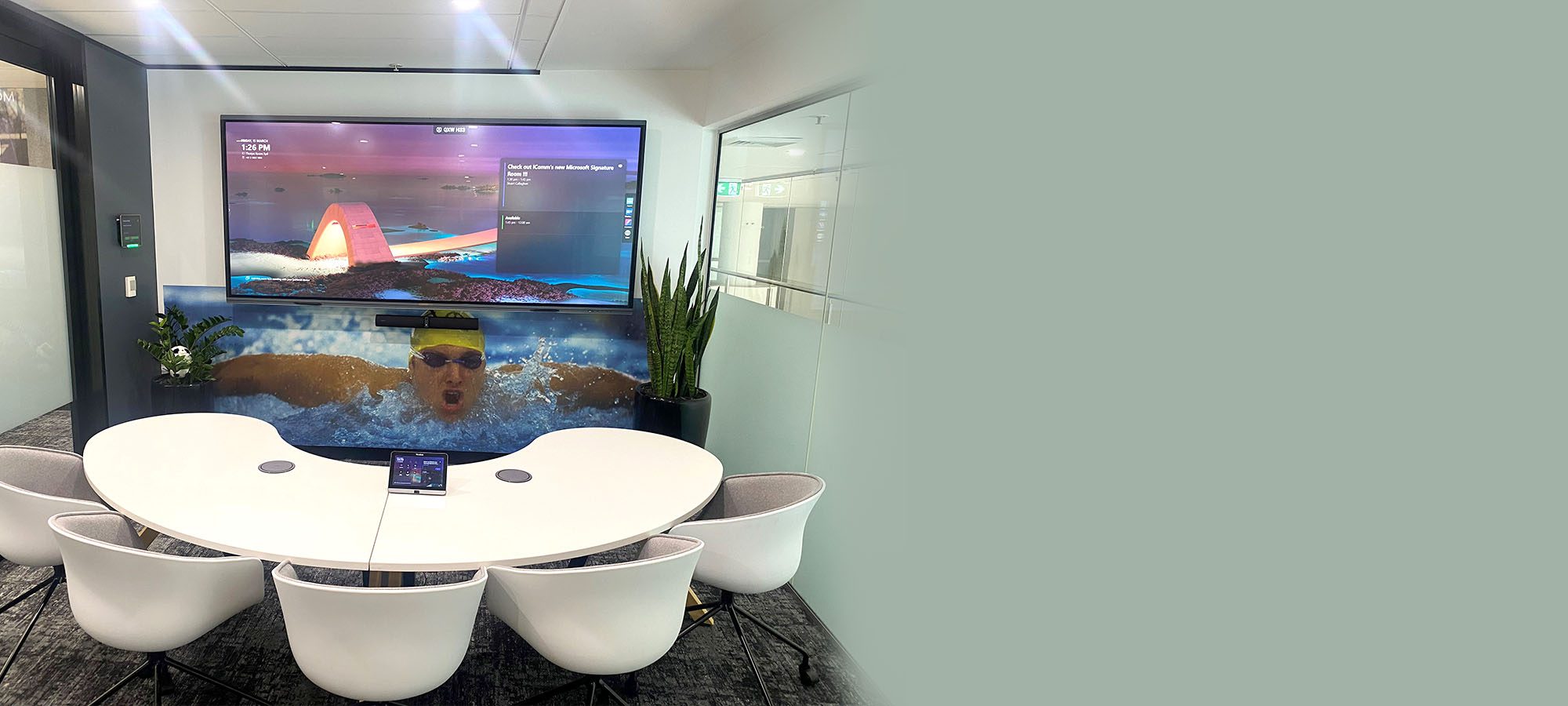Photo of Microsoft Signature Room with curved table, modern looking chairs and large screen